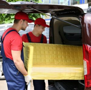 Günstig umziehen in Butzbach Günstig umziehen in Butzbach: Umzugshelfer laden ein gelbes Sofa in einen Transporter