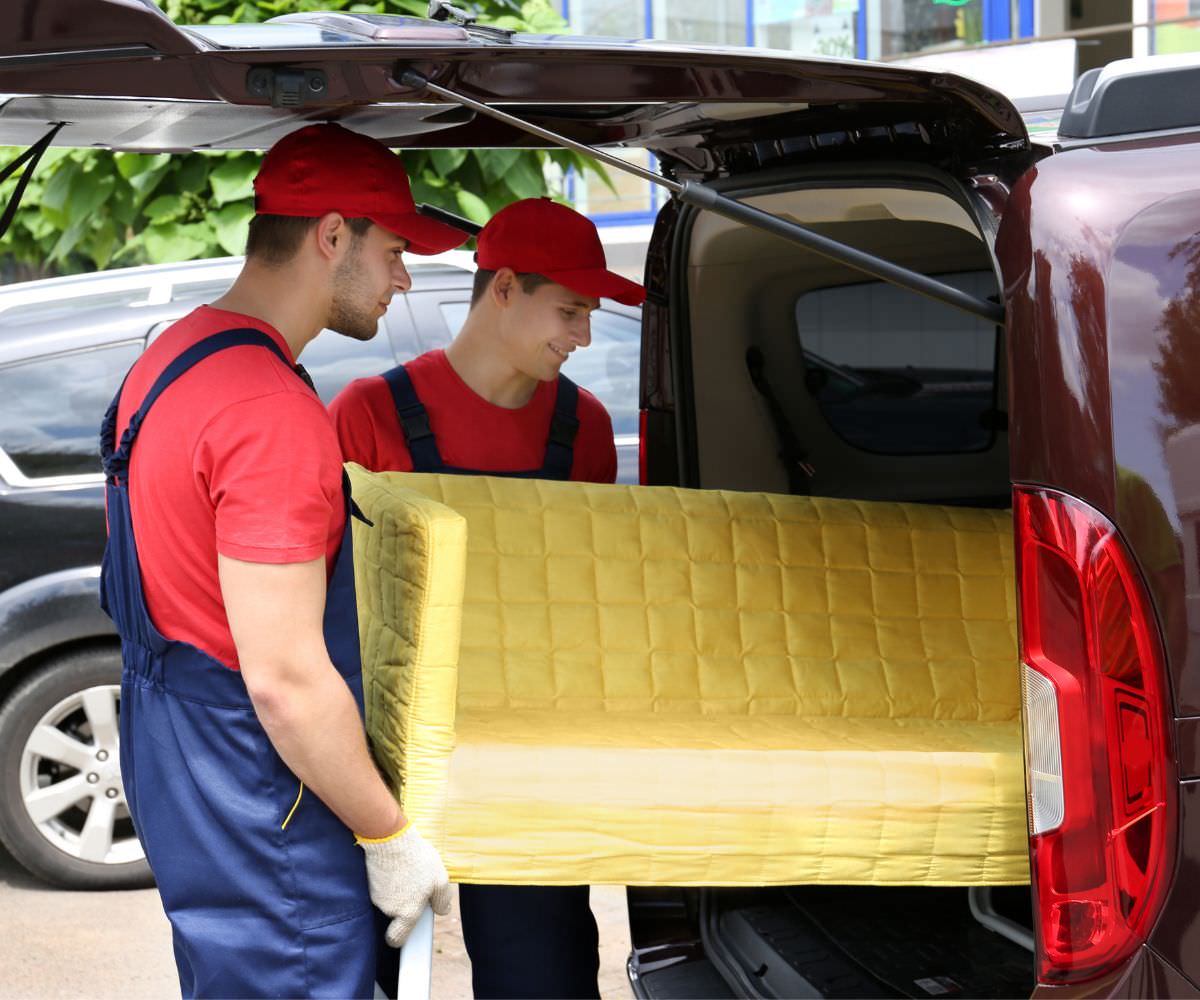 Umzugshelfer laden ein gelbes Sofa in einen Transporter – Preiswert umziehen Butzbach