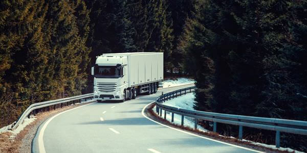 Klaviertransport Butzbach: Lkw fährt auf einer kurvigen Straße durch den Wald