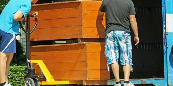 Möbellift Butzbach: Zwei Helfer tragen einen Holzschrank aus einem Lkw